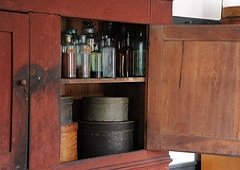 shaker kitchen cupboard filled with old herb bottles