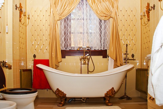 gold bathroom with claw foot bathtub