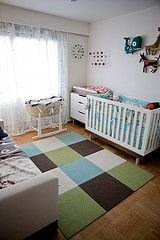 white nursery with large colorful block rug